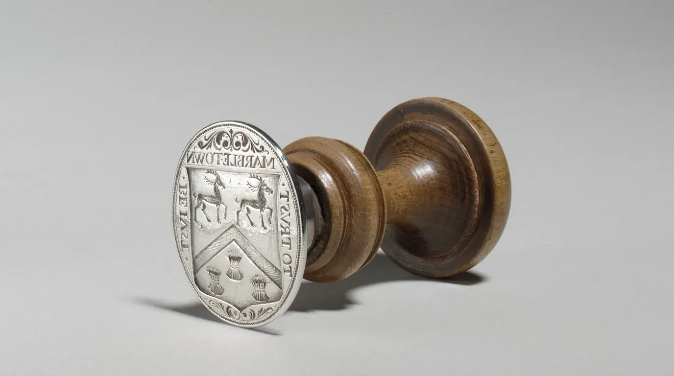 A silver seal by Jacob Boelen (c. 1704) with a turned wooden handle, its face engraved with a coat of arms.