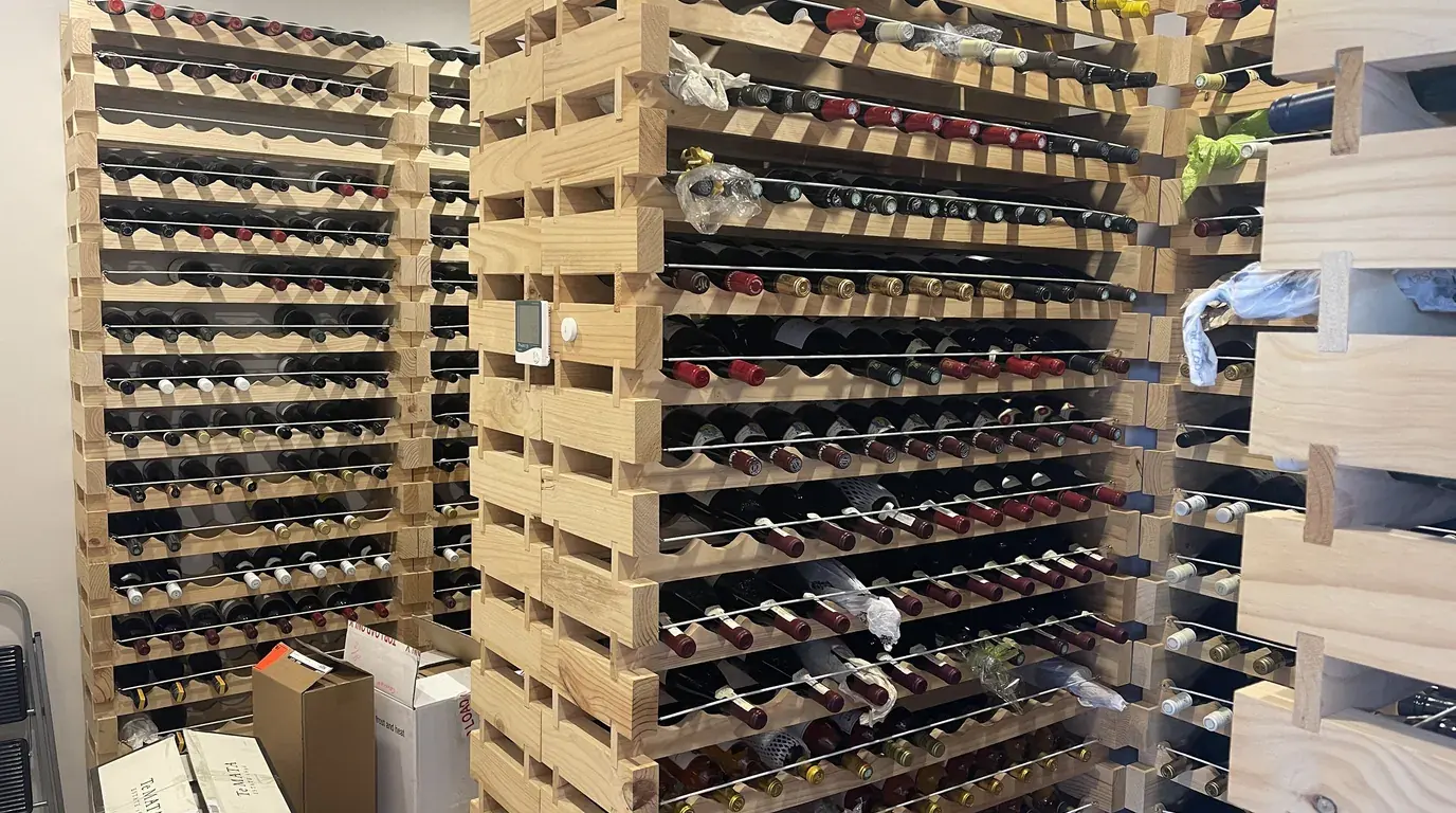 Home wine storage: bottles laid on their sides in stacked wooden racks.