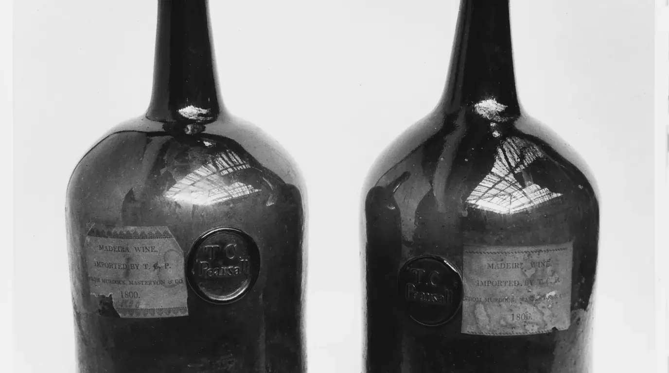 Two British wine bottles of about 1800, each with an applied glass seal and a paper label.